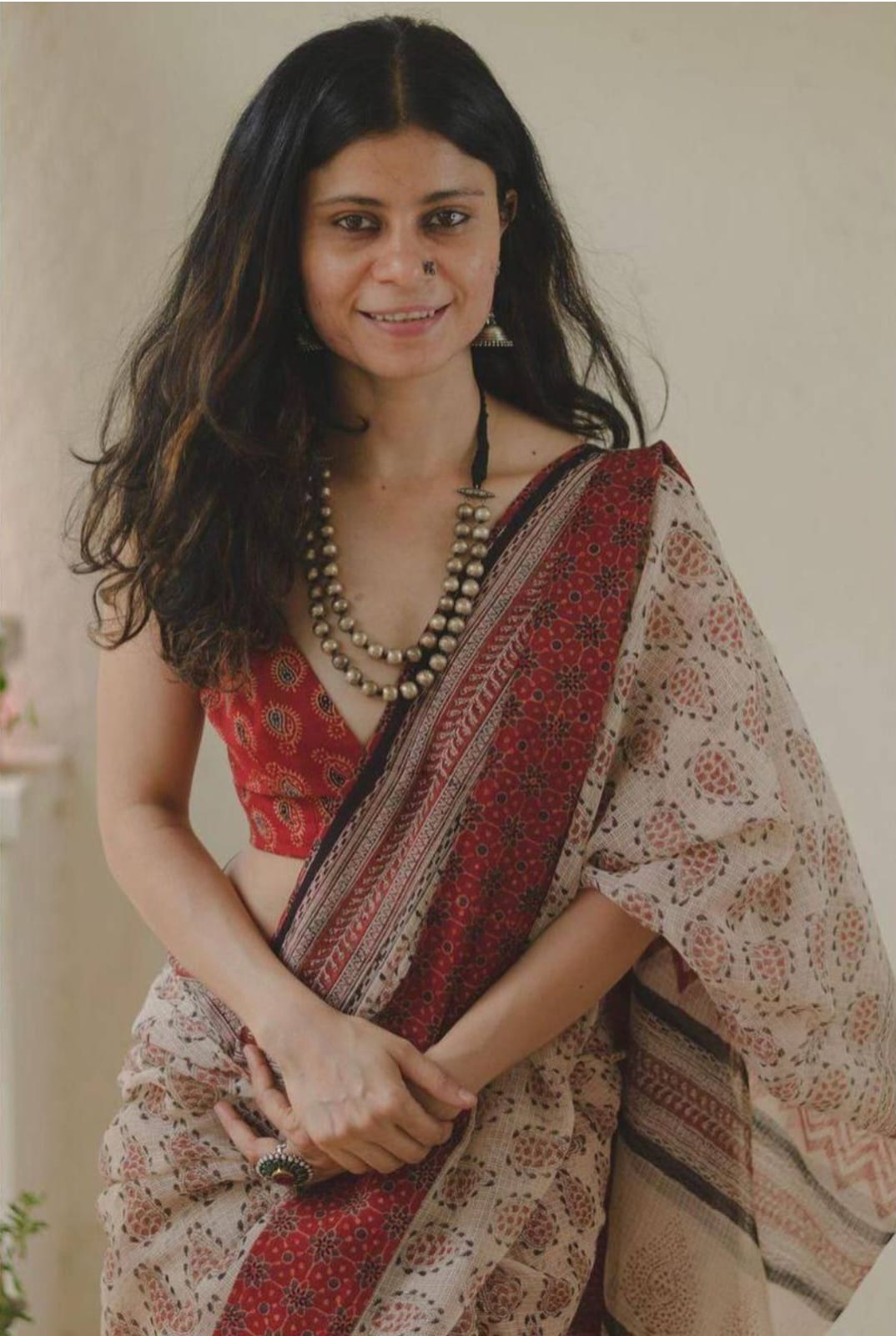 Model wearing a beige linen digital printed saree with floral motifs and matching blouse piece

